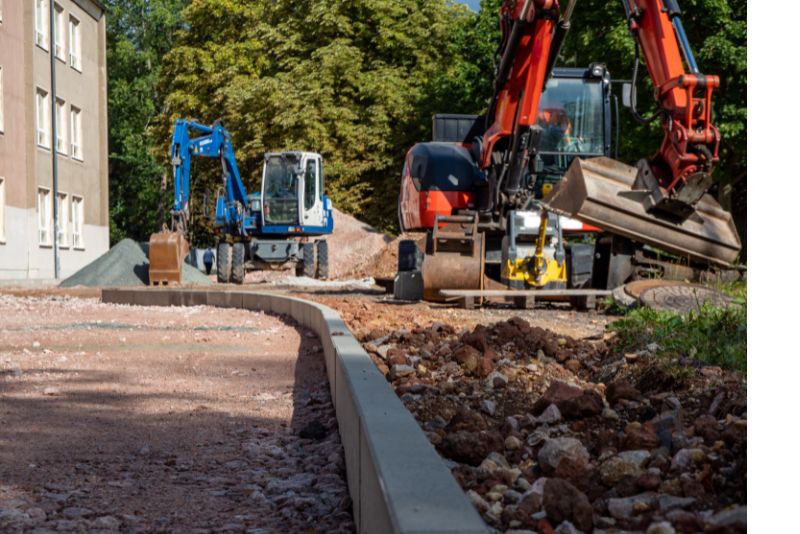 An excavator is seen doing some sxtraction and the area is being lwvwlled ready for landscaping
