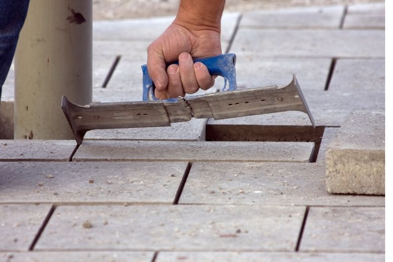 Pavers are being measured to ensure a perfect fit on the ground